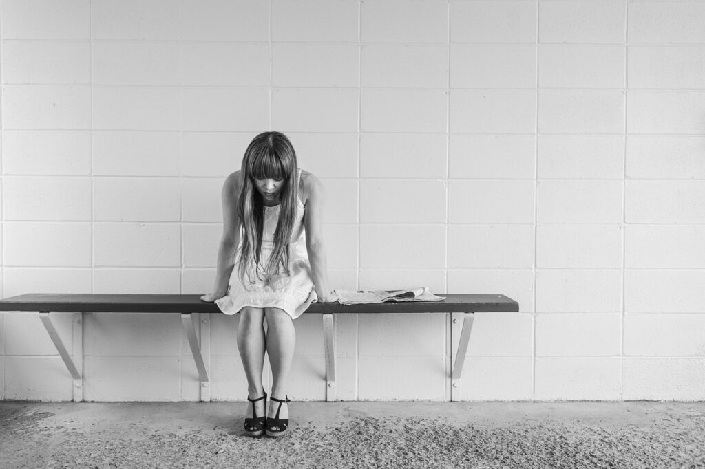 worried girl, woman, waiting, sitting, thinking, worry, black and white, sad girl, sad, expression, people, person, depression, sadness, emotion, unhappy, adult, depressed, grief, frustration, despair, human, problem, stressed, young, female, girl, long hair, dress, bench, concrete, wall